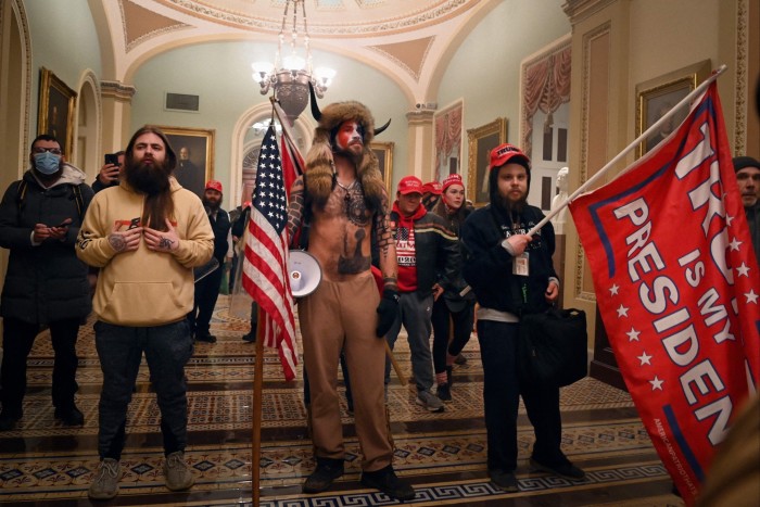 Supporters of US President Donald Trump, including QAnon conspiracy group member Jake Angeli, also known as Yellowstone Wolf, center, enter the US Capitol on January 6, 2021