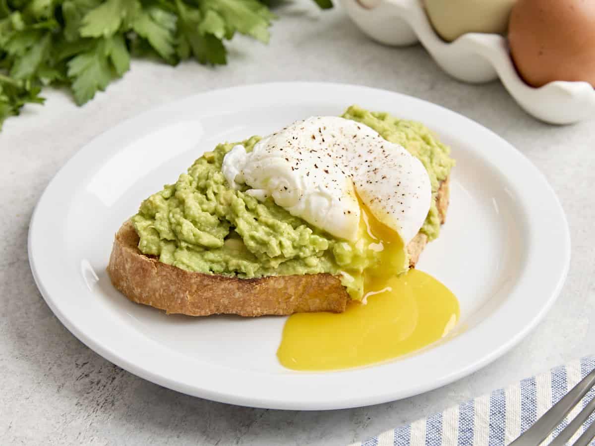 Side view of a poached egg on avocado toast.