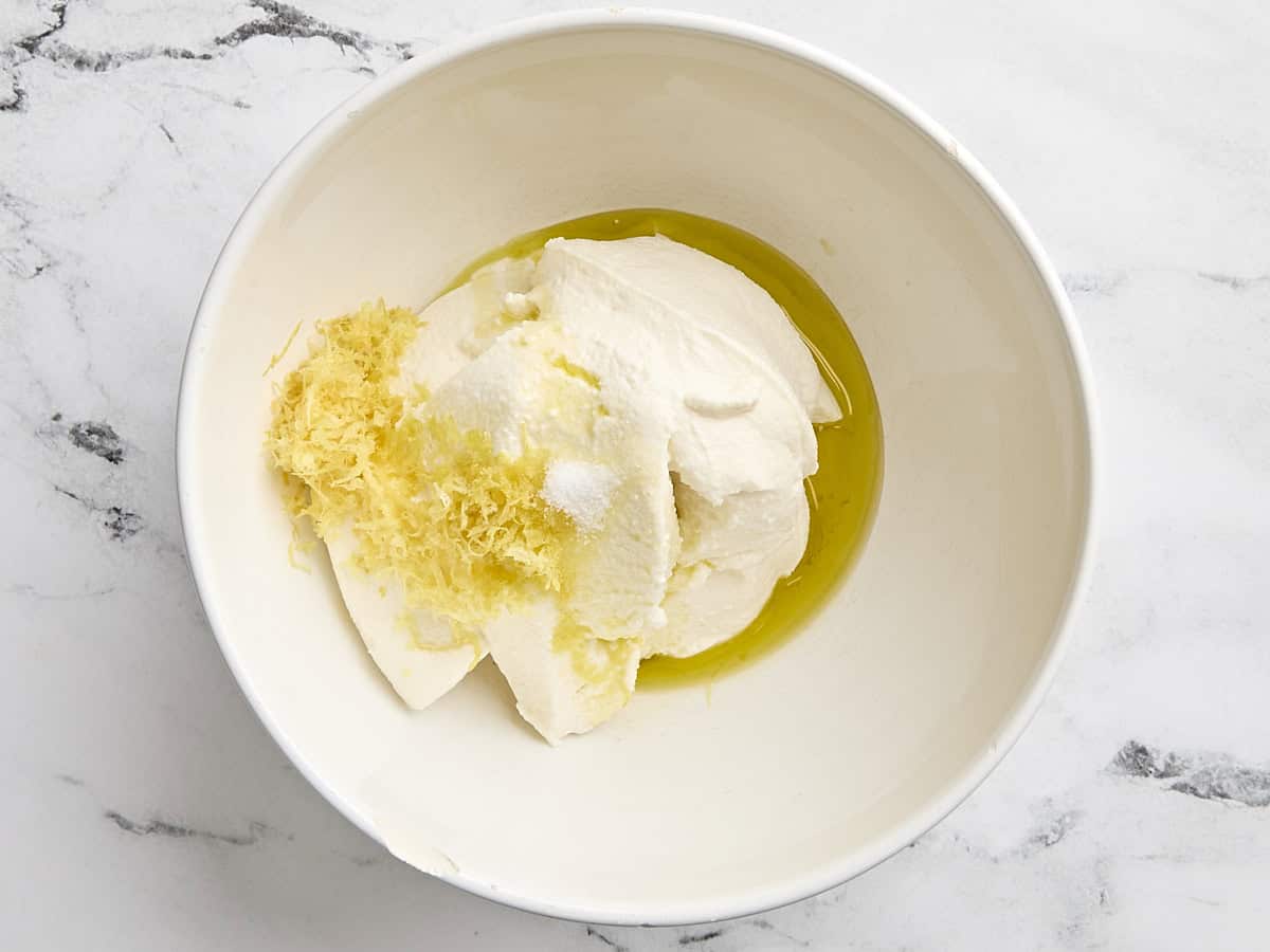 Ricotta, olive oil, and lemon zest in a mixing bowl.