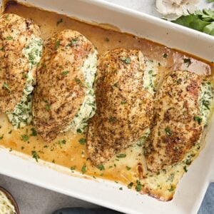 Overhead view of spinach stuffed chicken breasts in a baking dish.