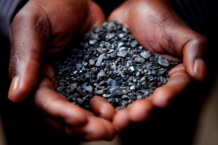 A miner in the Democratic Republic of the Congo carries tantalum stones